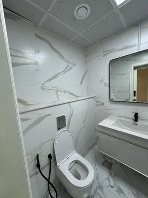 a white bathroom with a toilet and a sink at Burj Khalifa & Canal View Apartment in Dubai