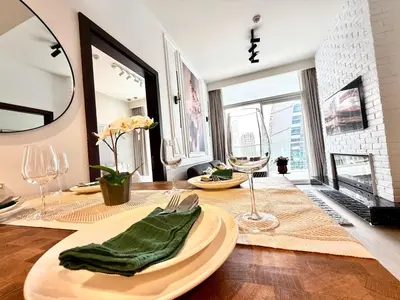 a dining room with a table with a green napkin at Luxury 2BR Downtown Apartment - Canal & City Views in Dubai