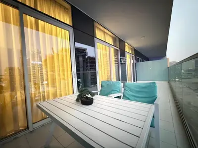 a table with a potted plant sitting on a balcony at Luxury 2BR Downtown Apartment - Canal & City Views in Dubai
