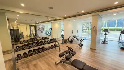 a gym with a lot of exercise equipment and mirrors at Charming & Cozy 1BR Burj Khalifa Skyline View in Dubai