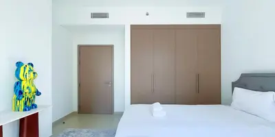 a bedroom with a large white bed and a closet at Luxury in Dubai 2 bedroom apartment with balcony in Dubai