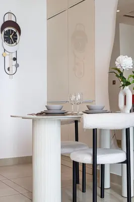 a dining room with a table and two stools at Livin' Holidays - 1 BR - Paradise getaway Dubai Marina in Dubai
