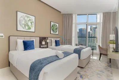 a hotel room with two beds and a desk at Picture-Perfect Canal and City Views, Minutes from Waterfront Transport, Easy Access to Downtown Delights, Prive by Damac B, Business Bay by Deluxe Holiday Homes in Dubai