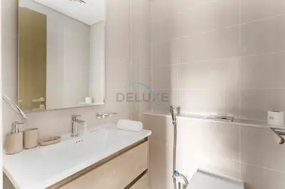 a bathroom with a sink and a toilet and a mirror at Picture-Perfect Canal and City Views, Minutes from Waterfront Transport, Easy Access to Downtown Delights, Prive by Damac B, Business Bay by Deluxe Holiday Homes in Dubai