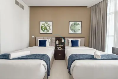 a room with two beds with blue pillows at Picture-Perfect Canal and City Views, Minutes from Waterfront Transport, Easy Access to Downtown Delights, Prive by Damac B, Business Bay by Deluxe Holiday Homes in Dubai