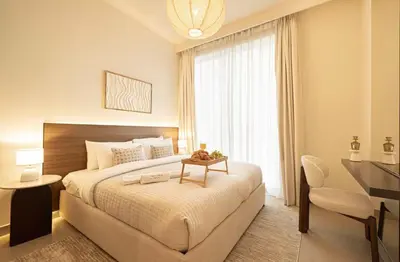 a bedroom with a bed with a table and a desk at the space in Dubai