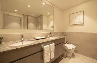 a bathroom with a sink and a toilet and a mirror at the space in Dubai