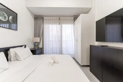 a bedroom with a large bed and a flat screen tv at HAVN - 1 bedroom in The Wings, Arjan in Dubai