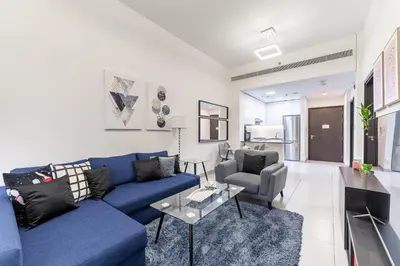 a living room with a blue couch and a table at HAVN - 1 bedroom in The Wings, Arjan in Dubai