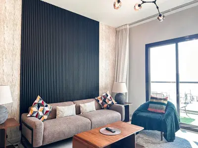 a living room with a couch and a table at Stunning 1 Bed Large Luxury Apt with Pool View Al Barari by Luxaura in Dubai