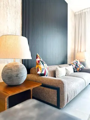 a living room with a couch and a table with a lamp at Stunning 1 Bed Large Luxury Apt with Pool View Al Barari by Luxaura in Dubai