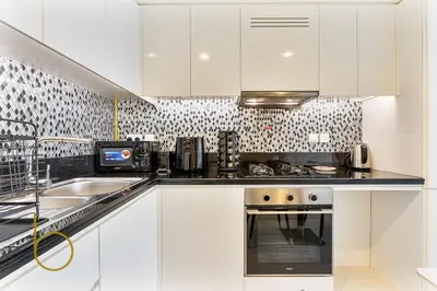 a white kitchen with a stove and a sink at Bookable 1 Bed Aykon City with Amazing Bird eye view in Dubai