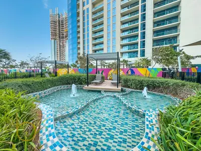 a swimming pool with two fountains in front of a building at Bookable 1 Bed Aykon City with Amazing Bird eye view in Dubai