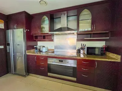 a kitchen with wooden cabinets and a stainless steel refrigerator at 3BR Luxury Burj Residence Full Burj Khalifa in Dubai