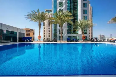 a large swimming pool with palm trees and buildings at Prime Location - Dubai Marina 1br - King Size Bed in Dubai