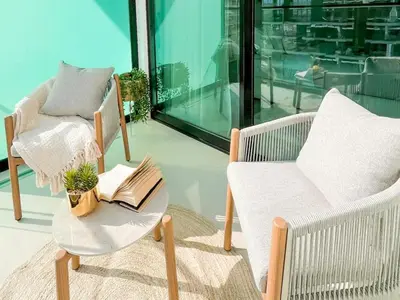 a balcony with two chairs and a table with a book at Radiant Studio in Binghatti Azure with Pool & Gym in Dubai