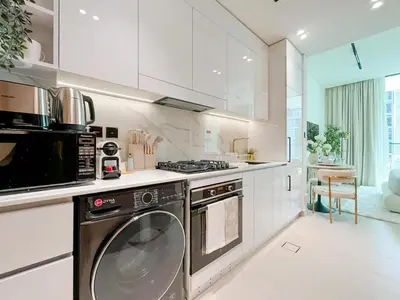 a kitchen with a stove and a dishwasher at Radiant Studio in Binghatti Azure with Pool & Gym in Dubai