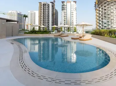 a swimming pool with chairs and umbrellas on a building at Binghatti Phantom 1BR Luxe Suite with Private Pool in Dubai