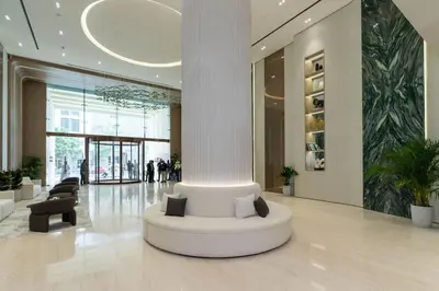 a lobby with a white column in a building at Binghatti Phantom 1BR Luxe Suite with Private Pool in Dubai