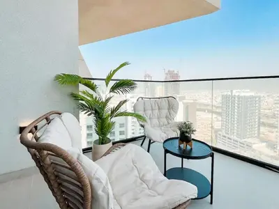 a living room with two chairs and a table on a balcony at Binghatti Phantom 1BR Luxe Suite with Private Pool in Dubai
