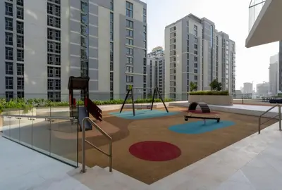 a playground in the middle of a city with tall buildings at Airy 1BR Oasis with Plunge Pool in Binghatti Phantom in Dubai