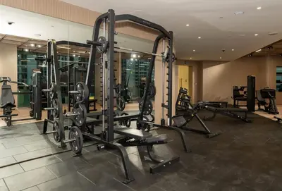 a gym with several tread machines in a room at Airy 1BR Oasis with Plunge Pool in Binghatti Phantom in Dubai