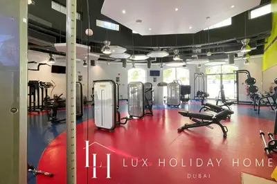 a gym with exercise equipment and a sign that reads us holiday home at LUX The Contemporary Marina View Suite 7 in Dubai