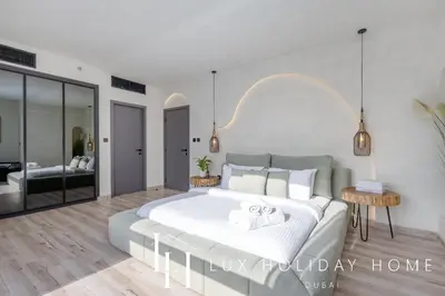 a bedroom with a large bed and a living room at LUX The Contemporary Marina View Suite 7 in Dubai