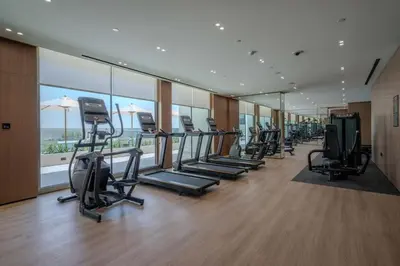 a gym with a row of treadmills and ellipticals at Beautifully Furnished Studio in Binghatti Azure in Dubai
