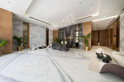 a lobby with a large white marble floor and a couch at Beautifully Furnished Studio in Binghatti Azure in Dubai