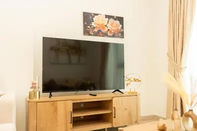 a flat screen tv sitting on top of a wooden entertainment center at 2 Bedroom Luxury In Jaddaf in Dubai