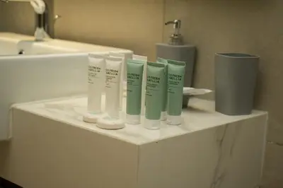 a counter with four bottles of moisturizers and a sink at 2 Bedroom Luxury In Jaddaf in Dubai