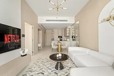a living room with a white couch and a table at VayK - Modern & Elegant 1BD in JVC in Dubai