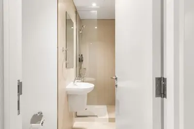 a white bathroom with a sink and a toilet at 4-BR Luxury Retreat with Iconic Burj Khalifa View in Dubai