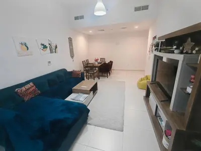 a living room with a blue couch and a table at Furnished 2 Bedroom Apartment with Balconies in Dubai