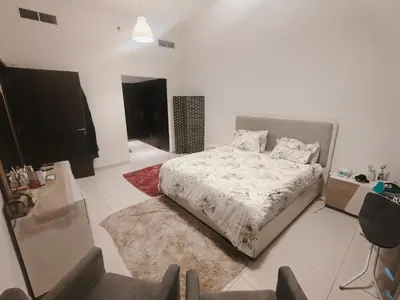 a white bedroom with a bed and a rug at Furnished 2 Bedroom Apartment with Balconies in Dubai
