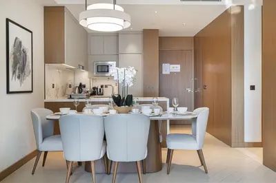 a kitchen and dining room with a table and chairs at Address Opera by NAMUVE in Dubai