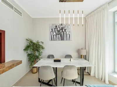 a dining room with a white table and chairs at Skyline Upscale 2 Bedroom Apartment I Steps to Burj Khalifa Dubai Fountain Dubai Mall I Mesmerizing Views I Free Gym, Pool, Parking & Wi-Fi in Dubai