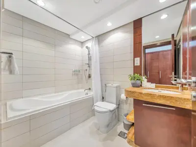 a bathroom with a tub and a toilet and a sink at Skyline Upscale 2 Bedroom Apartment I Steps to Burj Khalifa Dubai Fountain Dubai Mall I Mesmerizing Views I Free Gym, Pool, Parking & Wi-Fi in Dubai