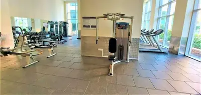 a gym with treadmills and machines in a building at Skyline Upscale 2 Bedroom Apartment I Steps to Burj Khalifa Dubai Fountain Dubai Mall I Mesmerizing Views I Free Gym, Pool, Parking & Wi-Fi in Dubai