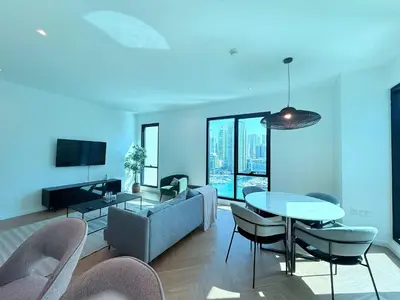 a living room with a couch and a table and chairs at Luxury Upgraded 2BR in Dubai Marina in Dubai