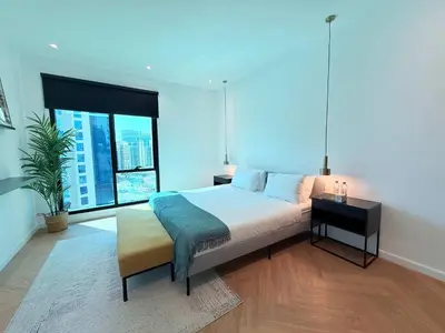 a bedroom with a large bed and a large window at Luxury Upgraded 2BR in Dubai Marina in Dubai