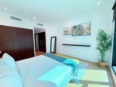 a bedroom with a large bed and a plant at Luxury Upgraded 2BR in Dubai Marina in Dubai