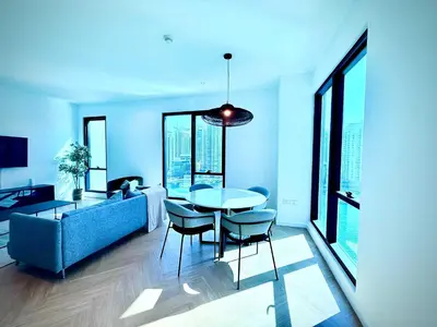 a living room with a couch and a table and chairs at Luxury Upgraded 2BR in Dubai Marina in Dubai