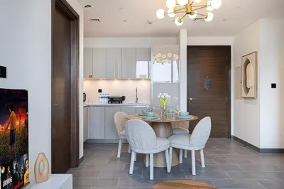 a kitchen and dining room with a table and chairs at Modern 2 Bedroom Apartment in Sobha Hartland in Dubai