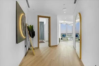 a hallway of a home with white walls and a mirror at Two Bedroom in Sobha Waves in Dubai