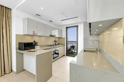 a kitchen with white cabinets and a counter top at Two Bedroom in Sobha Waves in Dubai