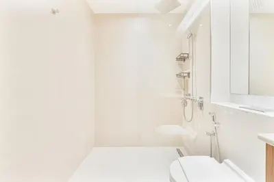a white bathroom with a toilet and a sink at Sunny & Stylish 1Bed 7-Min Walk to the Beach! in Dubai