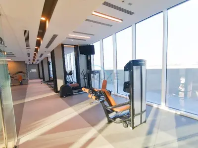 a gym with cardio equipment in a building with windows at Harbour-View 3BR with Assistant Room, Just a Stones Throw from Marine Transportation, Harbour Gate Tower 1, Creek Harbour by Deluxe Holiday Homes in Dubai