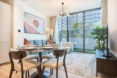 a living room with a table and chairs and a couch at STAY BY LATINEM Luxury 1BR Holiday Home CD 0602 Near Burj Khalifa in Dubai